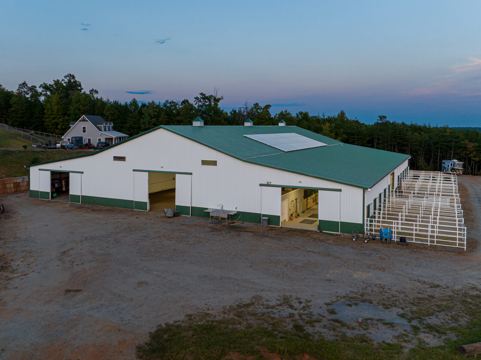 Barn and outdoor arena aerial view with solar panels